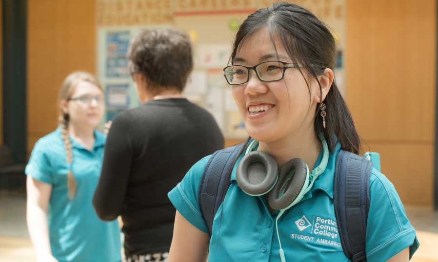 smiling young woman with headphones and backpack
